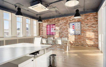 Moderne kantoorruimte huren aan Veerhaven 7 in Rotterdam Centrum met grote ramen, bakstenen muur en stijlvolle meubels. Ideaal voor zakelijke ontmoetingen.