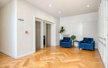Stijlvolle entree met houten vloer en blauwe stoelen in het kantoorpand op Veerhaven 7, ideaal om te overwegen voor kantoorruimte huren in Rotterdam Centrum.