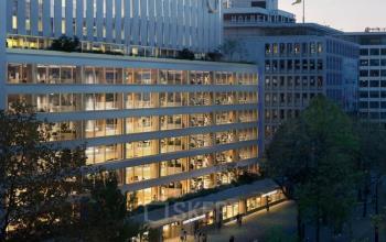 Buitenkant van een modern kantoorpand aan de Coolsingel 75 in Rotterdam Centrum, perfect voor wie kantoorruimte wil huren. Het gebouw is omringd door groen en heeft grote ramen voor veel natuurlijk licht.