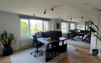 Moderne kantoorruimte te huur op Westplein 12 in Rotterdam Centrum met grote ramen, bureaus en stoelen op houten vloer.