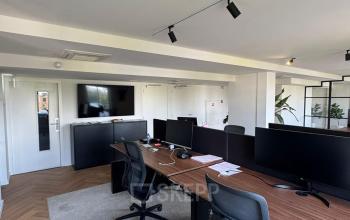 Moderne kantoorruimte op Westplein 12, Rotterdam Centrum met werkplekken voorzien van bureaus en stoelen, ideaal voor bedrijven die kantoor willen huren. Ruimte heeft een strakke, professionele uitstraling inclusief beeldschermen.