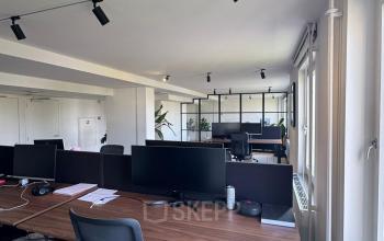Moderne kantoorruimte met bureaus en stoelen op Westplein 12, Rotterdam Centrum. Voorzien van grote ramen voor natuurlijk licht. Ideaal voor wie kantoorruimte wil huren in een dynamische omgeving.