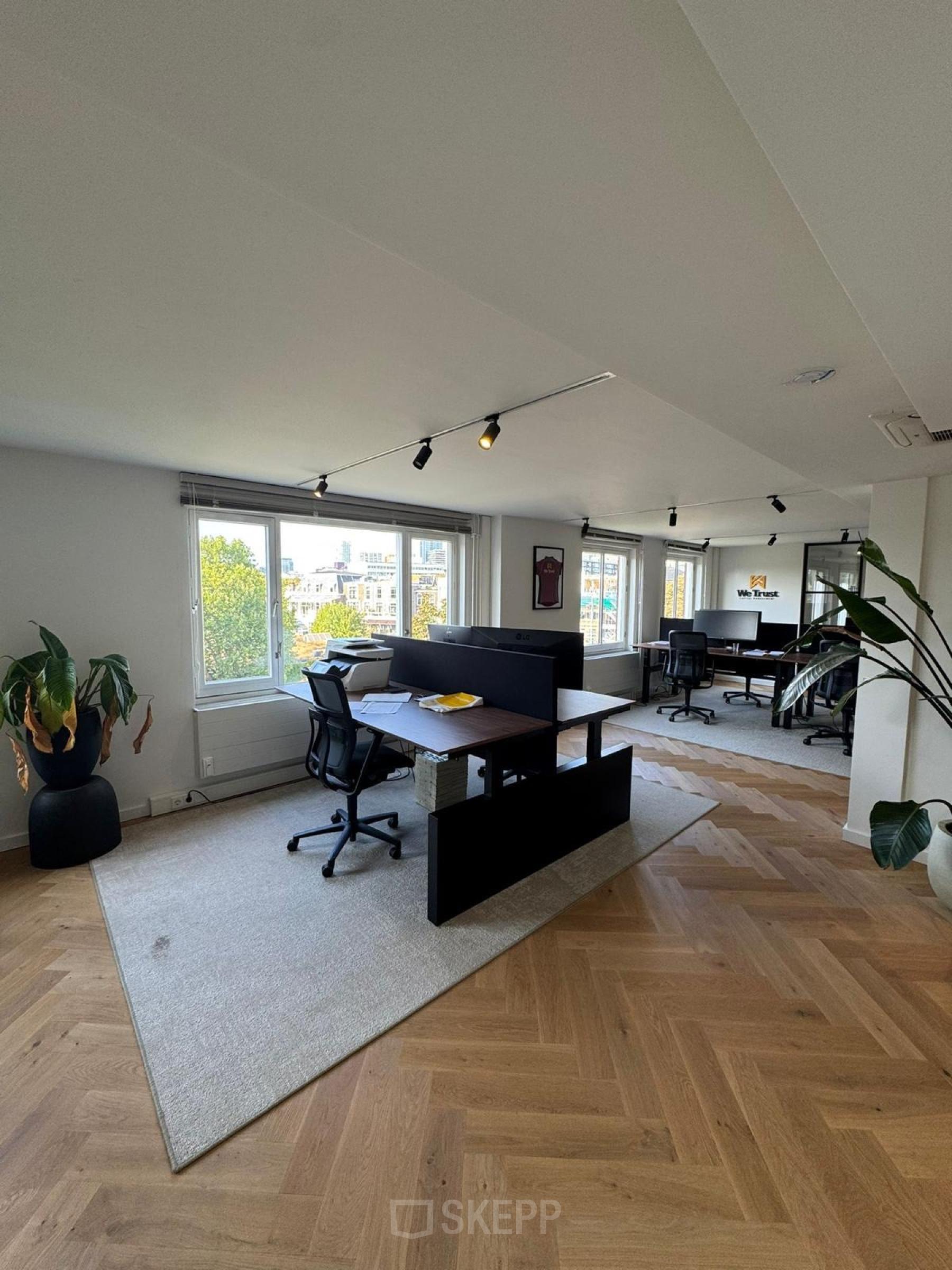 Moderne kantoorruimte te huur op Westplein 12 in Rotterdam Centrum met grote ramen, bureaus en stoelen op houten vloer.