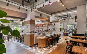 Kantoor huren op Coolsingel 104 in Rotterdam Centrum, modern ingericht met houten vloeren, hoge ramen en een bar, ideaal voor zakelijke bijeenkomsten.