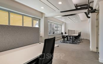 Binnenkant van een modern kantoorpand aan de Coolsingel 104 in Rotterdam Centrum met werkruimtes en bureaus.