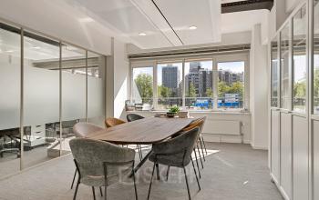 Lichte kantoorruimte te huur op Coolsingel 104 in Rotterdam Centrum met moderne vergadertafel en stoelen, grote ramen en uitzicht op de stad.