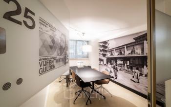 Vergaderruimte in het kantoorpand op Coolsingel 104, Rotterdam Centrum. Voorzien van glazen wanden en retro muurdecoratie.