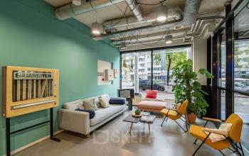 Moderne en uitnodigende lounge in kantoorpand aan Westblaak 180 in Rotterdam met comfortabele zitgelegenheid en huiselijke decoratie.