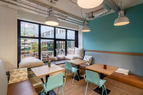 Gezellige gemeubileerde kantoorruimte huren op Westblaak 180, Rotterdam Centrum, met zithoek, tafels en stoelen bij grote ramen.
