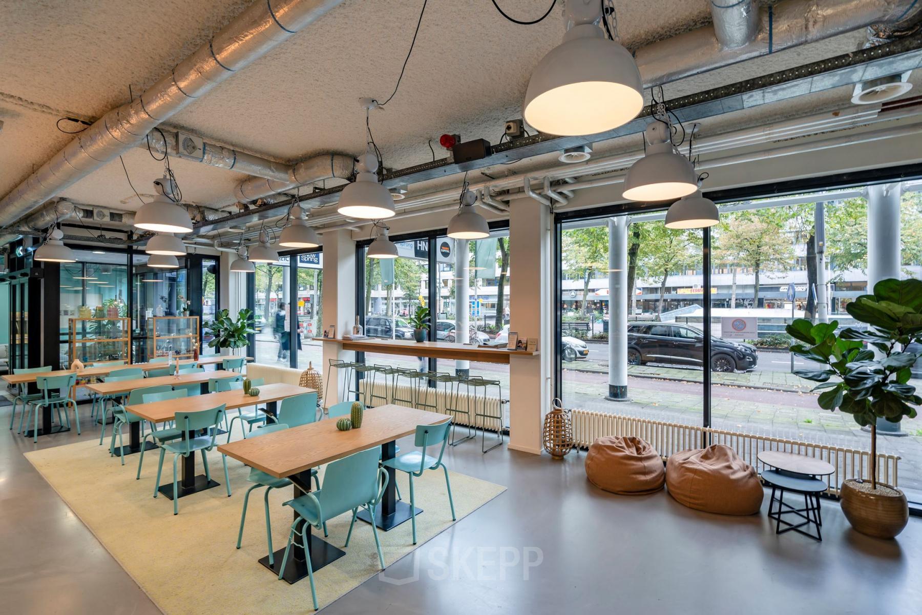 Modern ingerichte kantoorruimte huren aan Westblaak 180, Rotterdam Centrum, met grote ramen, meerdere tafels en stoelen, en een goed verlichte omgeving.