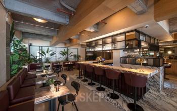 Kantoorpand op Beursplein 37, Rotterdam Centrum met moderne gemeubileerde werk- en ontmoetingsruimte, voorzien van marmeren tafels en planten.