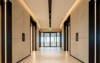 Interieur van het kantoorpand op Beursplein 37, Rotterdam Centrum, met moderne liften en strakke verlichting.