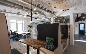 Kantoorpand aan Schiedamse Vest 154, Rotterdam Centrum met moderne werkplekken en vergadercabines, voorzien van industriële inrichting en grote ramen voor veel natuurlijk licht.