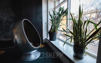 Kantoorruimte huren aan Schiedamse Vest 154 in Rotterdam Centrum met een uniek metalen ei-vormige stoel en veel natuurlijk licht.