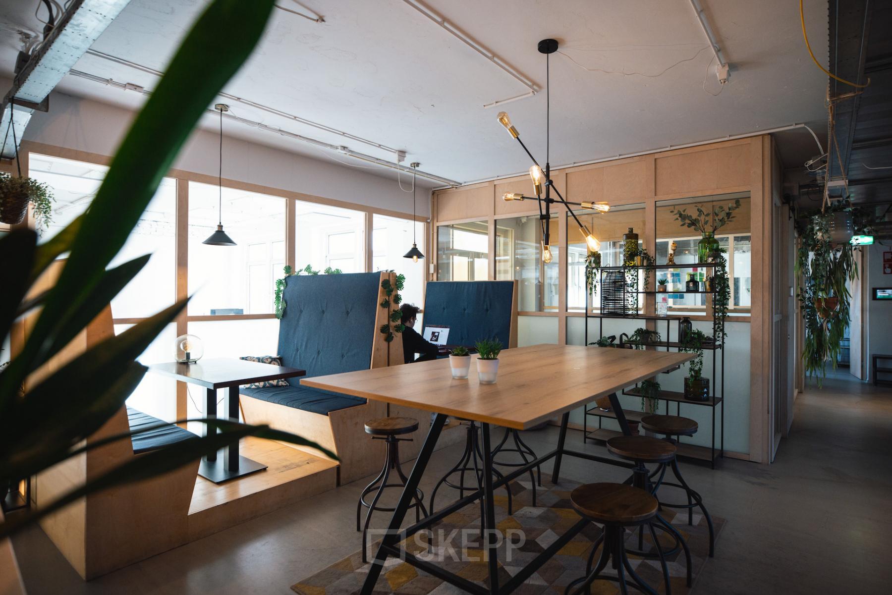 Sfeervolle kantoorruimte huren op Schiedamse Vest 154, Rotterdam Centrum met moderne inrichting, hoge tafels en banken, planten en veel natuurlijk licht.