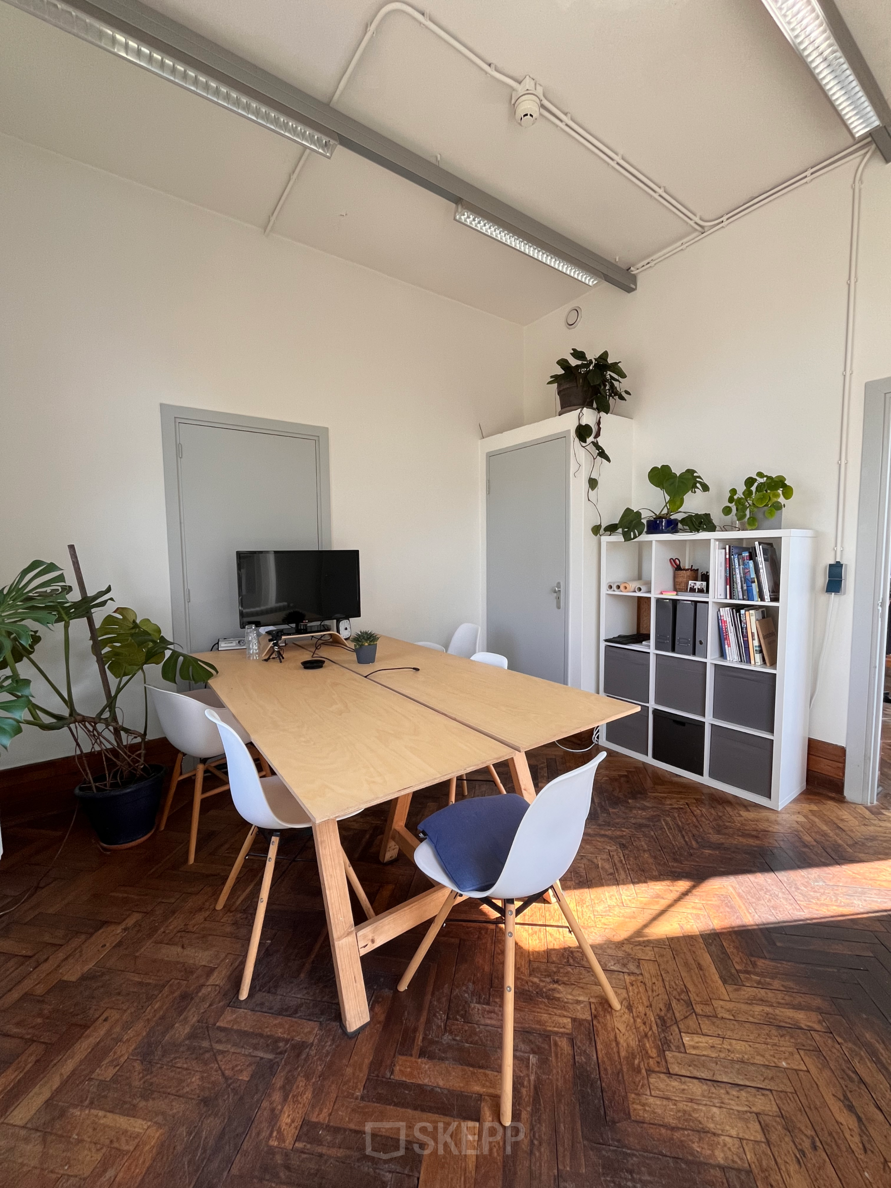 Kantoorruimte huren op Willem Buytewechstraat 45 in Rotterdam Delfshaven, ingericht met houten tafel, stoelen, monitor en planten.