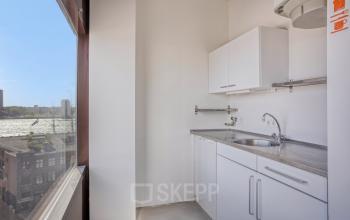 Compacte pantry in kantoorpand aan de Kratonkade 7 - 27, Rotterdam Delfshaven, met een helder raam dat uitzicht biedt op de omgeving.