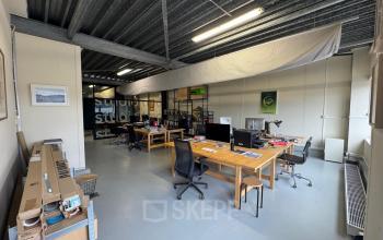 Kantoorruimte op Van Helmontstraat 17-23 in Rotterdam Delfshaven, lichte werkplekken met bureau en stoelen. Ideaal voor het huren van een kantoorpand. Tafels zijn ingericht met computerschermen en kantoorbenodigdheden.