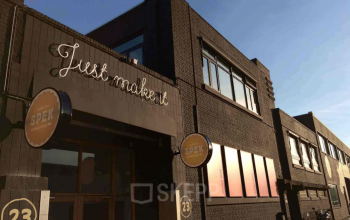 Industrieel kantoorpand aan Van Helmontstraat 17-23 in Rotterdam Delfshaven met moderne gevel en opvallend uithangbord, ideaal voor unieke kantoorruimte huren.