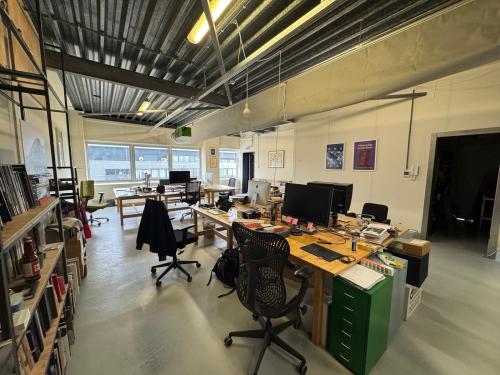 Kantoorruimte huren op Van Helmontstraat 17-23 in Rotterdam Delfshaven, ingericht als open werkruimte met bureaus, stoelen en persoonlijke spullen. Ruimte is licht en functioneel voor kantoren.