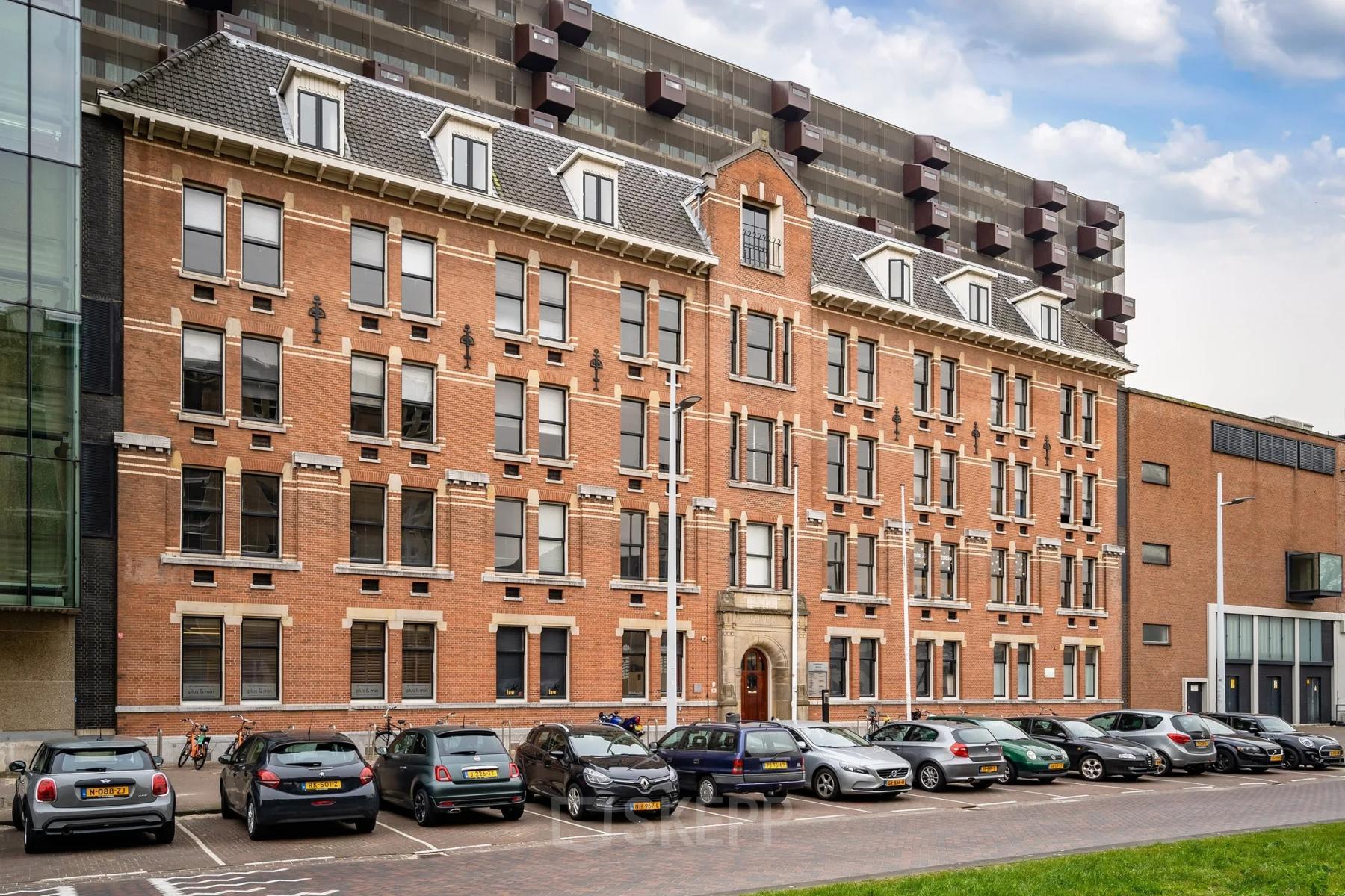 Buitenzijde van een karakteristiek kantoorpand aan de Lloydstraat 5 in Rotterdam Delfshaven met geparkeerde auto's op de voorgrond.