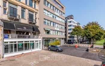 Buitenzicht op kantoorpand aan Haringvliet 76, Rotterdam Haringvliet, met geparkeerde auto's ervoor. Ideale locatie voor kantoorruimte huren, modern gebouw naast klassieke architectuur.