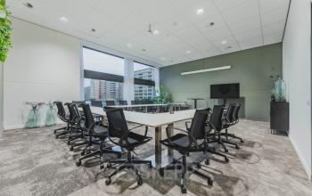 Moderne vergaderruimte in een kantoorpand aan Oostmaaslaan 71, Rotterdam Kralingen, voorzien van een grote tafel omringd door stoelen, met uitzicht op de stad.