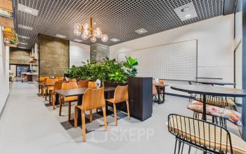 Moderne kantoorruimte in Rotterdam Kralingen aan de Oostmaaslaan 71, met houten tafels, stoelen en veel groen voor een inspirerende werkomgeving.
