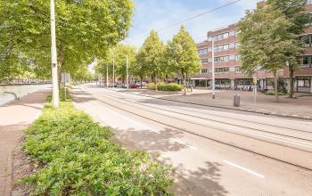 Exterieur van het kantoorpand gelegen aan Linker Rottekade 292 in Rotterdam Noord, met naastgelegen trambaan en groene omgeving.