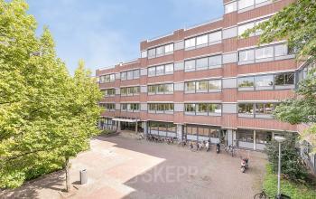 Exterieur van het kantoorpand op Linker Rottekade 292 in Rotterdam Noord, met zicht op de voorgevel en fietsenrekken ervoor. Ideaal voor bedrijven die kantoorruimte willen huren.