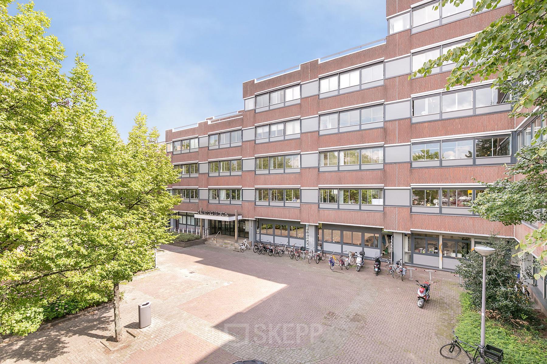 Exterieur van het kantoorpand op Linker Rottekade 292 in Rotterdam Noord, met zicht op de voorgevel en fietsenrekken ervoor. Ideaal voor bedrijven die kantoorruimte willen huren.