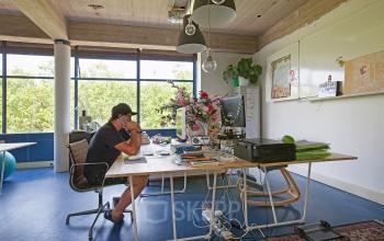 Kantoorruimte huren op Vijverhofstraat 47 in Rotterdam Noord, met personen aan het werk achter bureaus en kleurrijke inrichting.