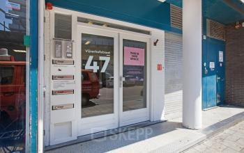 Voorkant kantoorpand Vijverhofstraat 47 in Rotterdam Noord, voorzien van glazen deur met huisnummer, en een rij brievenbussen aan de linkerkant.