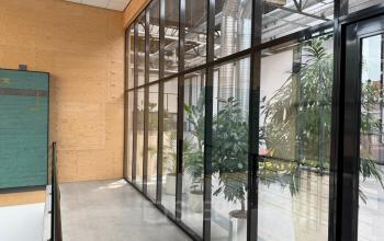 Moderne kantoorruimte huren aan Scheepsbouwweg 29, Rotterdam Waalhaven met glazen wanden, planten en betonnen vloer.