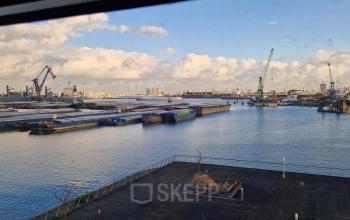 Uitzicht vanuit een kantoor op Waalhaven Zuidzijde 21, Rotterdam, met een panoramisch zicht op de haven met kranen en schepen.
