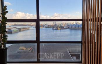 Uitzicht vanuit een kantoorruimte op de Waalhaven met zicht op de haven en kranen, Rotterdam.