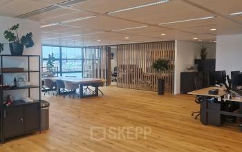 Ruime en lichte kantoorruimte aan Waalhaven Zuidzijde 21 in Rotterdam met houten vloer, diverse werkplekken en grote ramen voor veel natuurlijk licht. Uitstekende keuze voor kantoorruimte huren.
