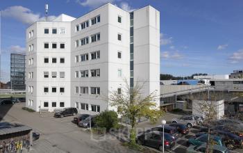 white office building many windows parking spots