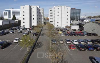 two white office buildings cars parking spots