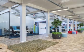 Kantoorruimte in Schiedam aan de Overschieseweg 34 met werkplekken, planten en moderne indeling. Kantoorruimte huren mogelijk.