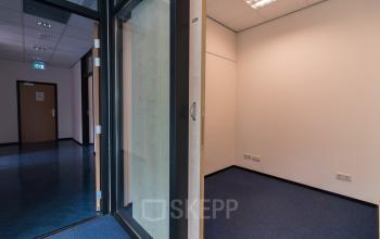 Kantoorruimte huren bij Noordvest 18, Schiedam, met blauwe vloerbedekking en houten deuren.
