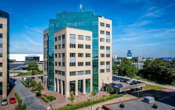 Hoog kantoorgebouw aan de Overschieseweg 304-332 in Schiedam, omgeven door parkeerplaatsen. Ideaal voor bedrijven die kantoorruimte huren in de regio. Grote ramen en modern design onderscheiden dit kantoorpand.