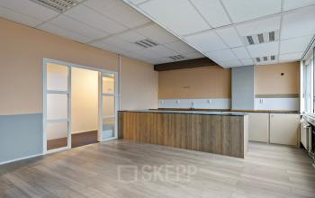 Interieur van een leeg kantoor op de Brauwweg 52-66, Schiedam, met lichte muren, houten vloer en ingebouwde kast; kantoorruimte huren mogelijk.