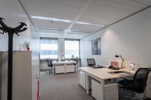 Moderne kantoorruimte huren op Schiphol Boulevard 127 met twee bureaus, opbergkasten en natuurlijke verlichting, ideaal voor zakelijke activiteiten.