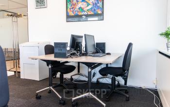 Modern ingerichte kantoorruimte met bureaus, computers en stoelen op Tupolevlaan 2-24 in Schiphol Rijk, heldere verlichting.