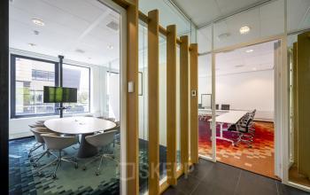 Conferentieruimte in kantoorpand Boeingavenue 223 – 239 te Schiphol Rijk, Schiphol met vergadertafels, stoelen, en een groot raam.