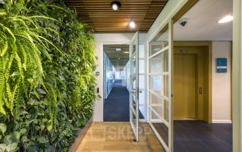 Kantoorpand Boeingavenue 223 – 239 in Schiphol Rijk met groene plantenwand en glazen deuren.