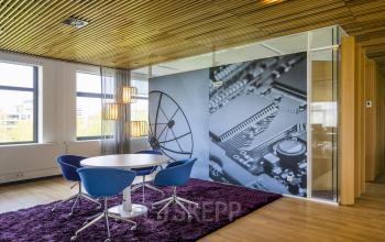 Vergaderruimte in kantoorpand op Boeingavenue 223 – 239, Schiphol Rijk, met modern interieur en grote muurschildering van een printplaat en satellietschotel.