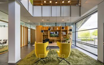 Kantoorruimte huren in Schiphol Rijk, gelegen op Boeingavenue 223 - 239, met moderne inrichting inclusief gele stoelen en een groene vloerbedekking.