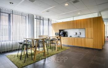 Interieur van moderne keuken en eetruimte met houten meubels in kantoorpand op Boeingavenue 223-239, Schiphol Rijk, Schiphol, geschikt voor kantoorruimte huren.
